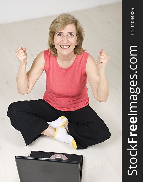Excited senior woman having success by using laptop and gesturing,top view,see more in People on couch or wooden floor. Excited senior woman having success by using laptop and gesturing,top view,see more in People on couch or wooden floor