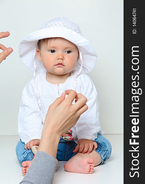 7 month old baby with hat being styled by mother. 7 month old baby with hat being styled by mother