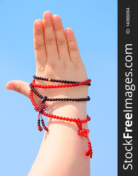 Prayer beads in her hands.Against the background of blue sky.