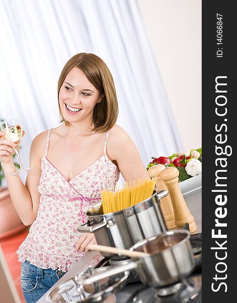 Attractive woman cooking spaghetti and tomato sauce in modern kitchen. Attractive woman cooking spaghetti and tomato sauce in modern kitchen