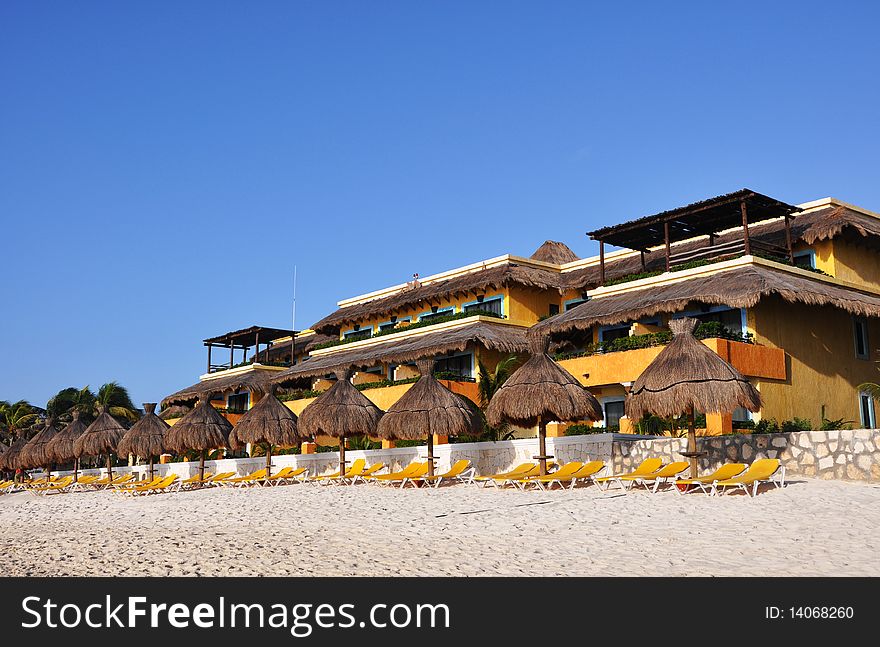 Sand, empty yellow plank beds, grassy umbrellas and the sea. Sand, empty yellow plank beds, grassy umbrellas and the sea.