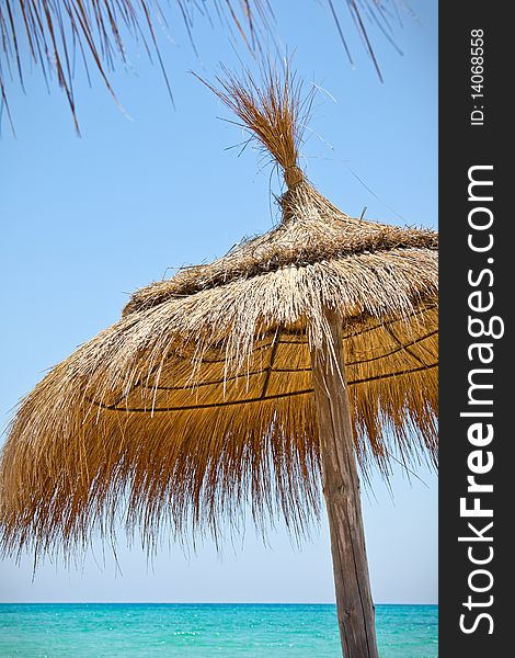 Sunshades on the beach of azure ocean in bright day