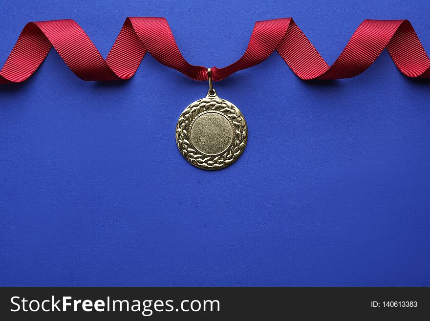 Gold medal with space for design on color background, top view. Victory concept