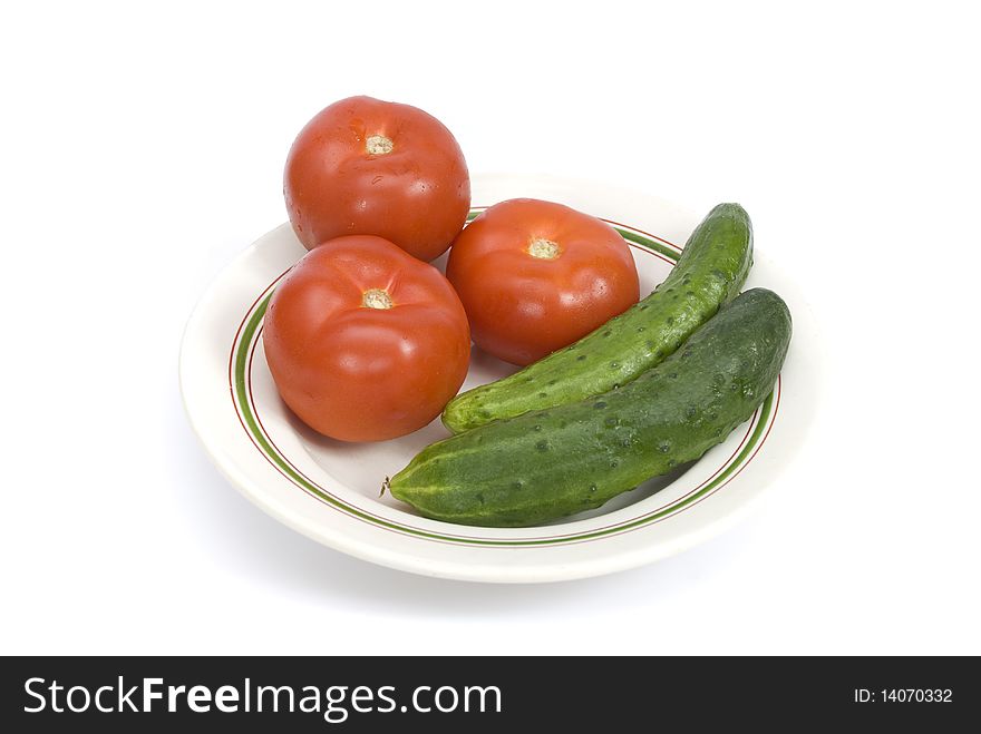 Tomatoes, cucumbers and radishes on a plate isolated on a white background. Tomatoes, cucumbers and radishes on a plate isolated on a white background