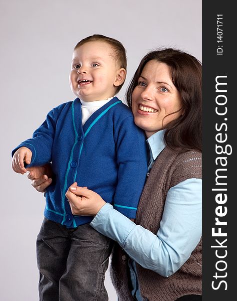 Smiling mother with son, studio shot, gray background. Smiling mother with son, studio shot, gray background