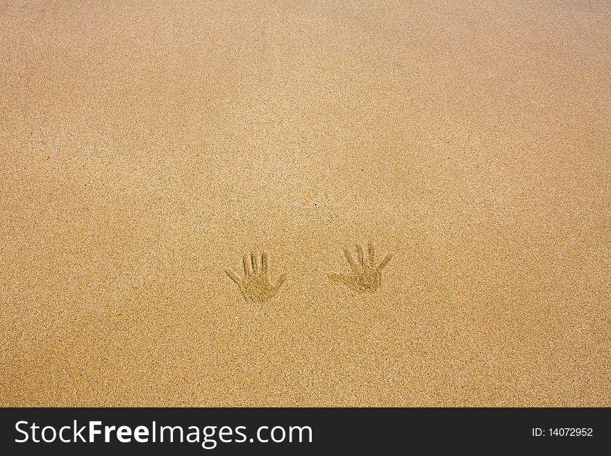 Handprints on a sandy beach