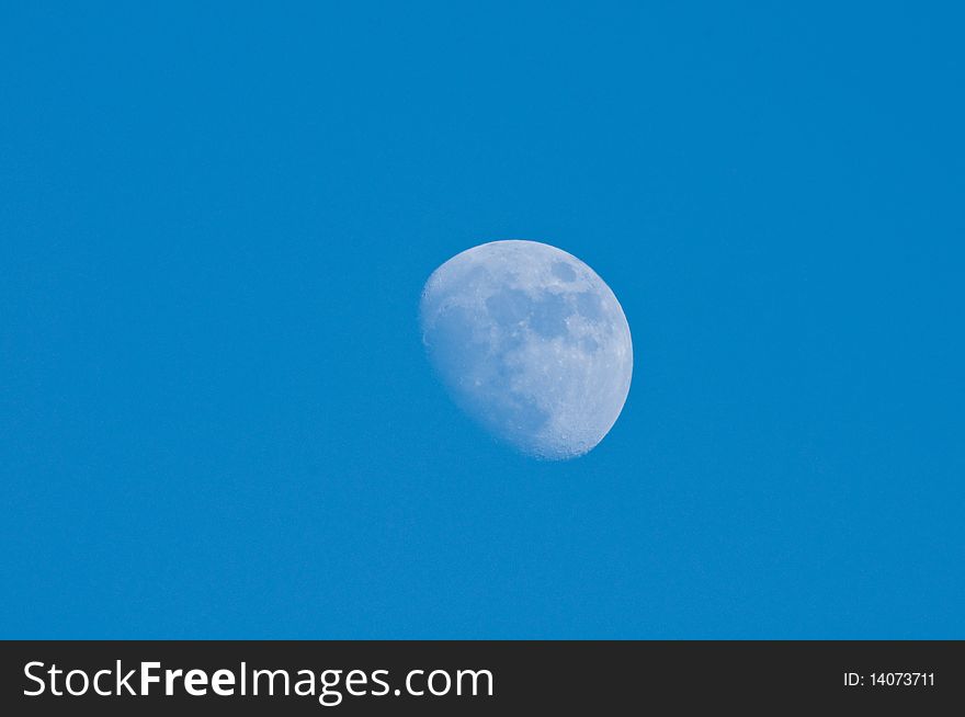 3/4 full moon at blue sky background