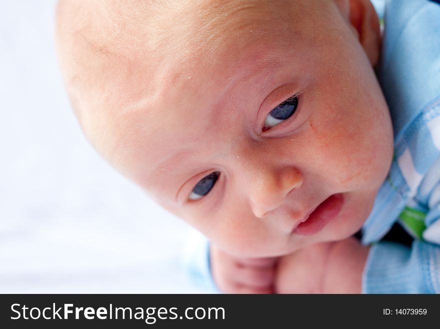 A very young baby boy child is photographed while he is 0-3 months old infant.
