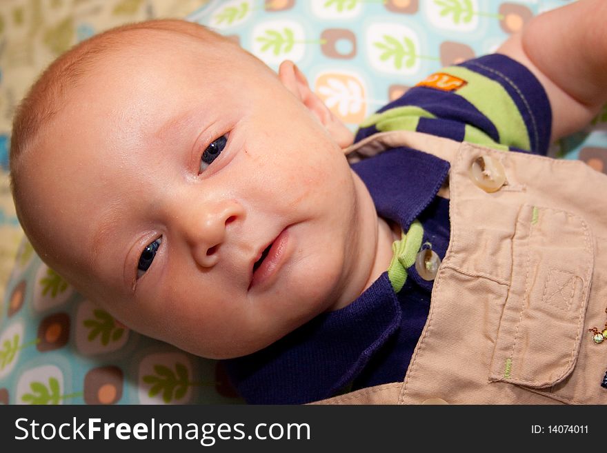 A very young baby boy child is photographed while he is 0-3 months old infant.