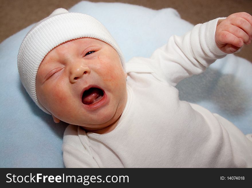 A very young baby boy child is photographed while he is 0-3 months old infant.