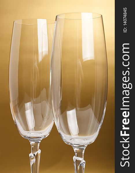 Two flutes with champagne on golden background. Two flutes with champagne on golden background