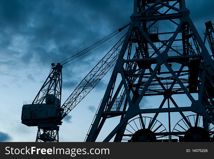 Two large dock cranes at night