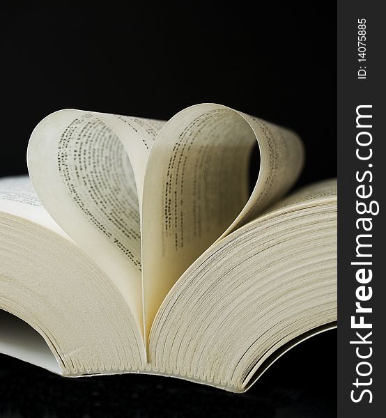 Heart shaped book on black background