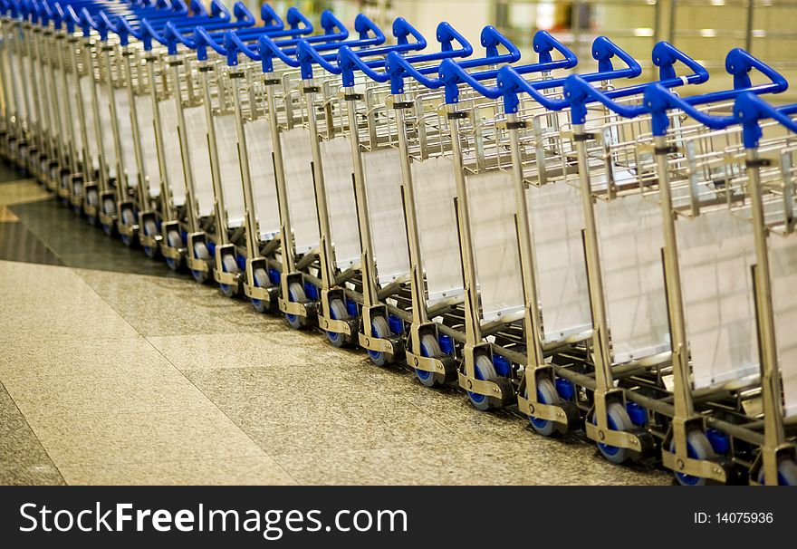 Picture of a stack row of airport luggage trolley.