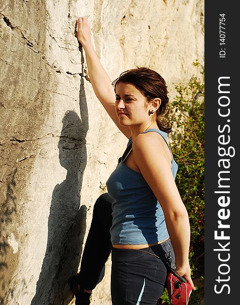 Young woman trying to climb a wall. Young woman trying to climb a wall