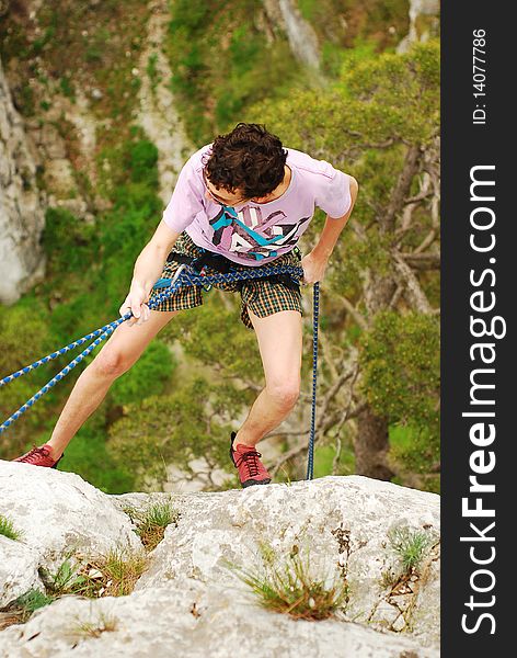 Climber in rappel after finishing the climb. Climber in rappel after finishing the climb