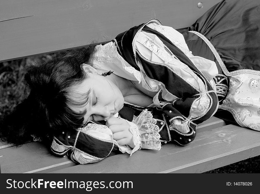 Girl in medieval dress lying on a bench. Girl in medieval dress lying on a bench