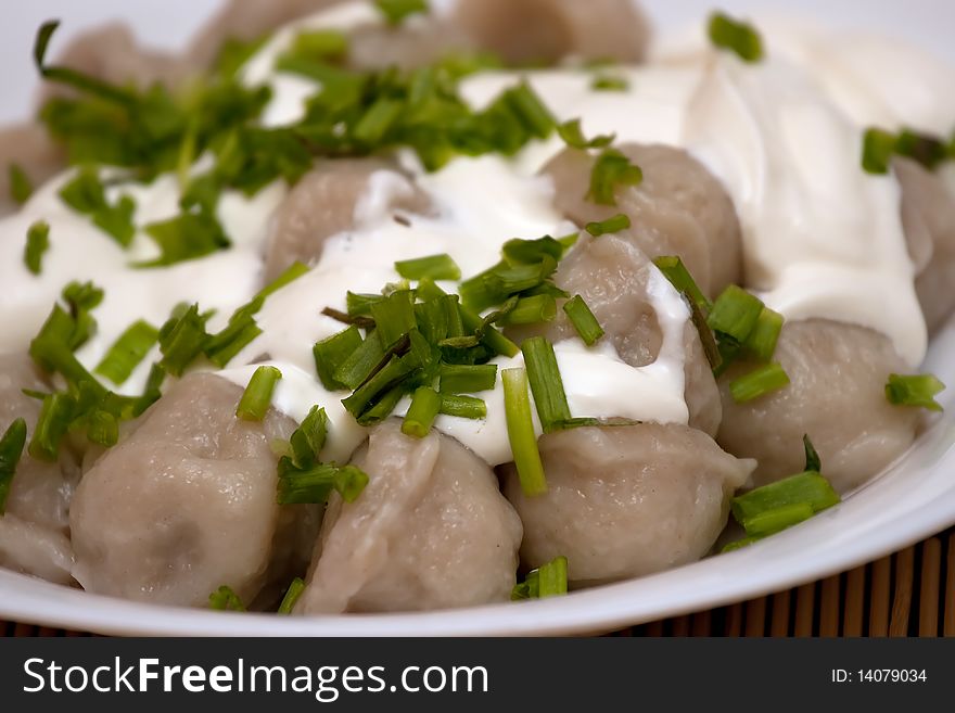 Meat dumplings with green onion and sour cream