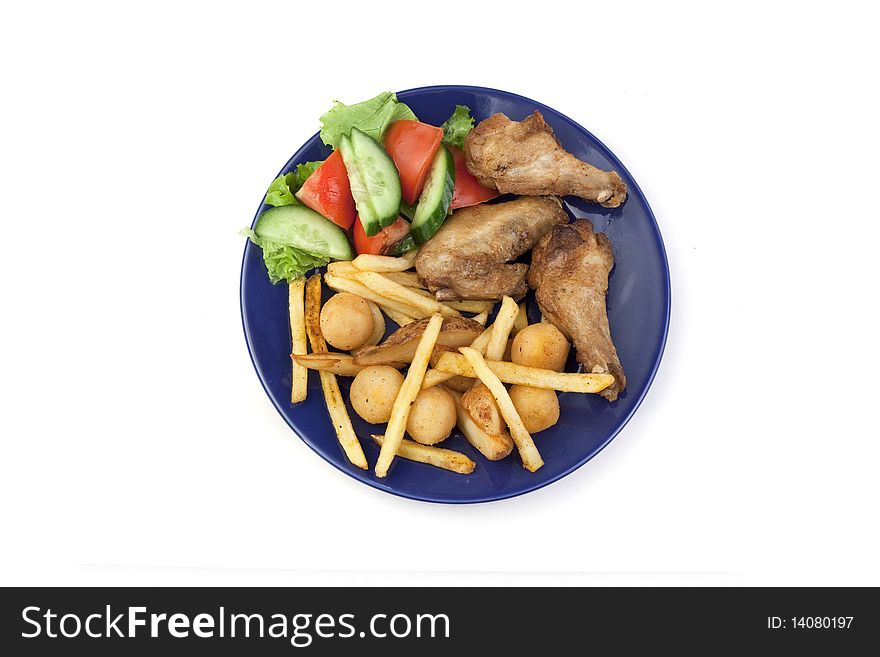 Vegetables, chicken wings, French fries in a plate. Vegetables, chicken wings, French fries in a plate