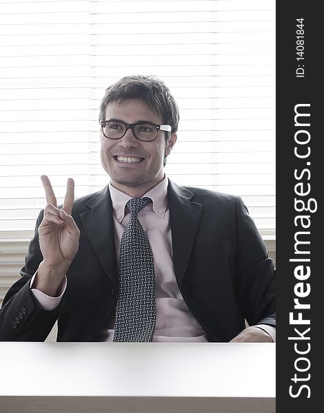 Businessman showing the victory sign. Businessman showing the victory sign