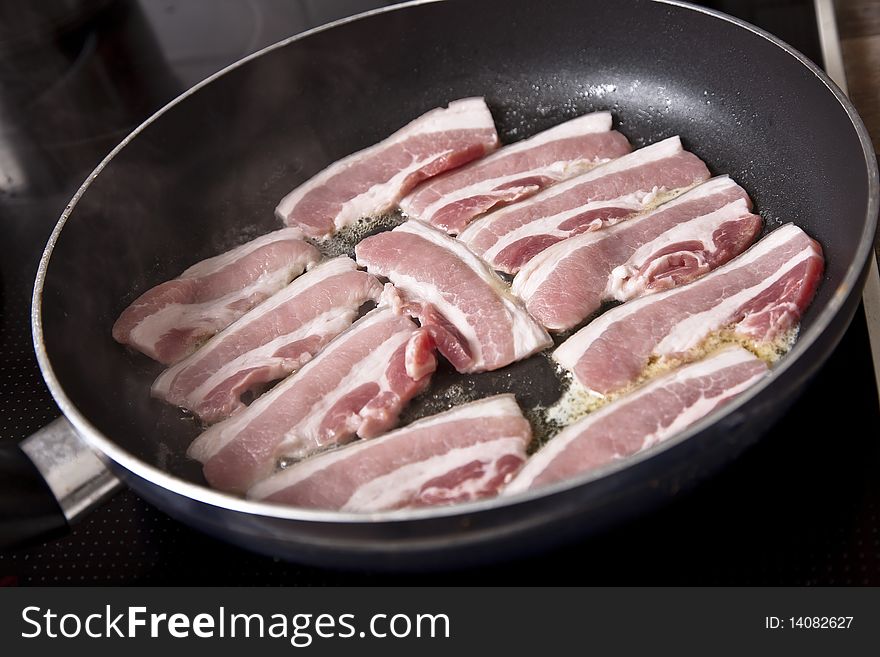 Thick pieces of pork frying in a pan. Thick pieces of pork frying in a pan