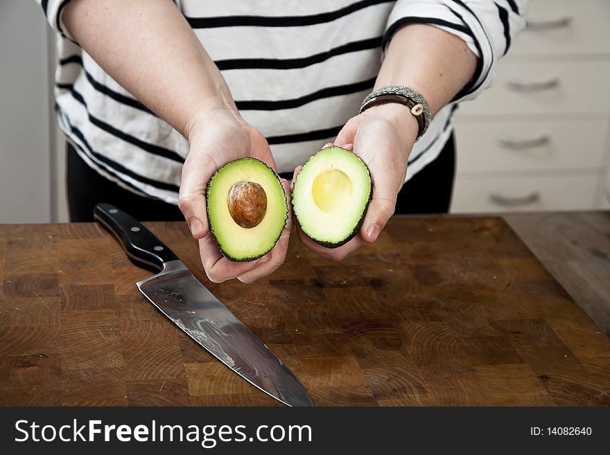 Female holding avocado in two halves