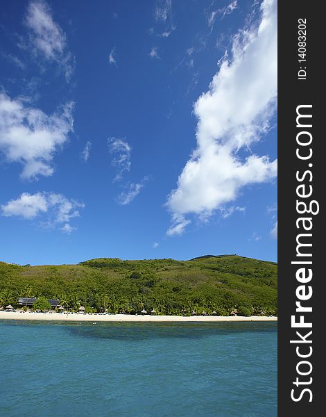 Tropical island with deep blue sea and beach huts.