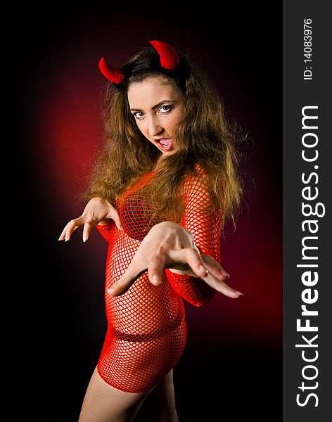 Beautiful brunette with red horns posing as imp