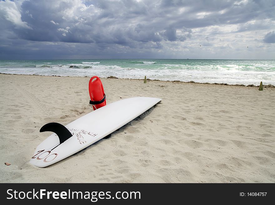 Lifeguard's surfboard on Miami's South Beach with dramatic cloudscape in the background. Lifeguard's surfboard on Miami's South Beach with dramatic cloudscape in the background.