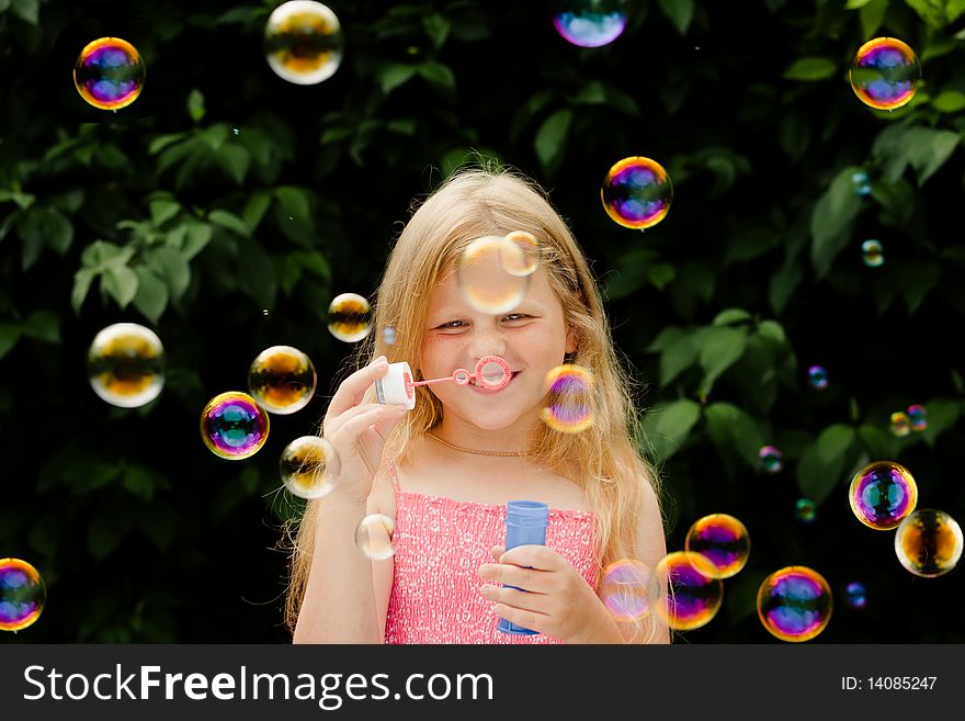 Small pretty girl is blowing soap bubbles. Small pretty girl is blowing soap bubbles