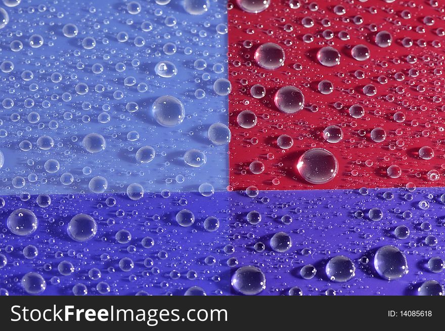 Pattern in drop of water on dark blue red background