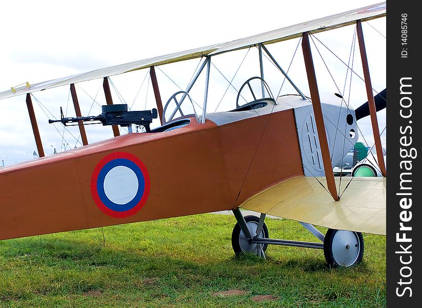 Old biplane parked in grass airfield