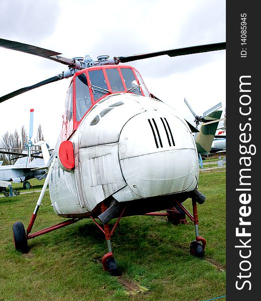 Old helicopter parked in grass airfield