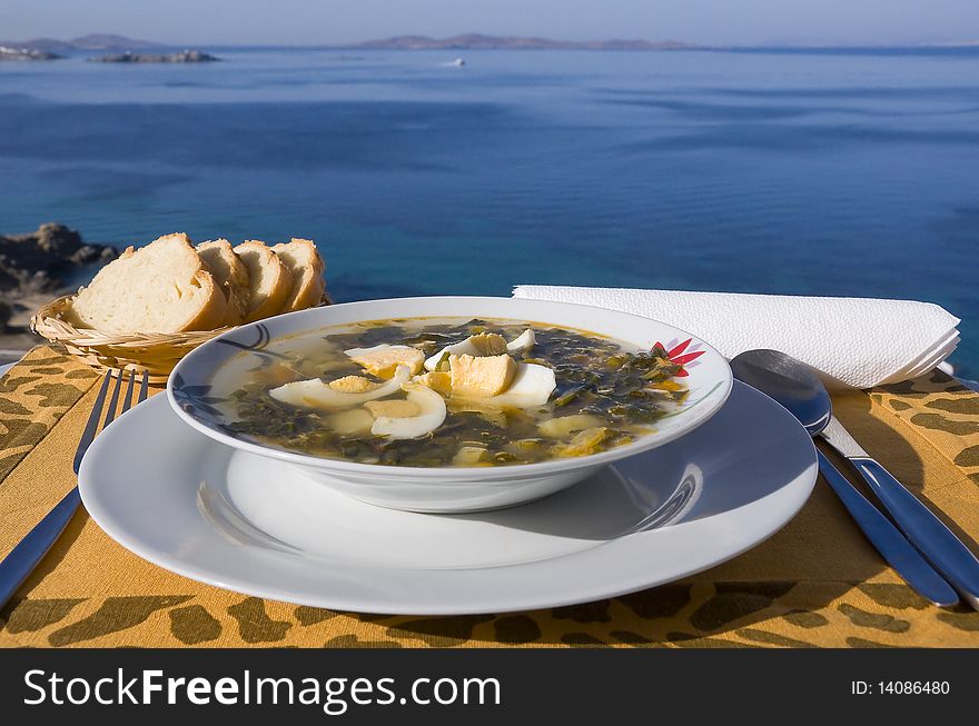 Vegetable soup with eggs on the table against the background of the sea. Vegetable soup with eggs on the table against the background of the sea...