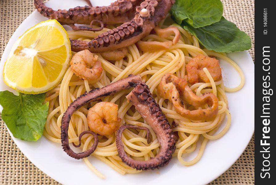 Pasta with seafood: octopus, squid and shrimp, decorated with lemon and herbs. Pasta with seafood: octopus, squid and shrimp, decorated with lemon and herbs