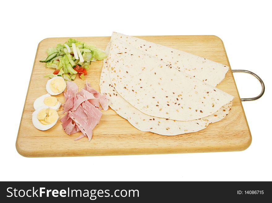 Seeded bread wraps and ingredients on a wooden board