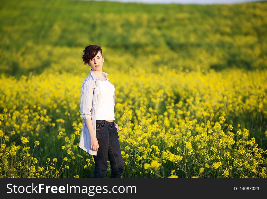 Young beautiful girl posing on a yellow field. Young beautiful girl posing on a yellow field.