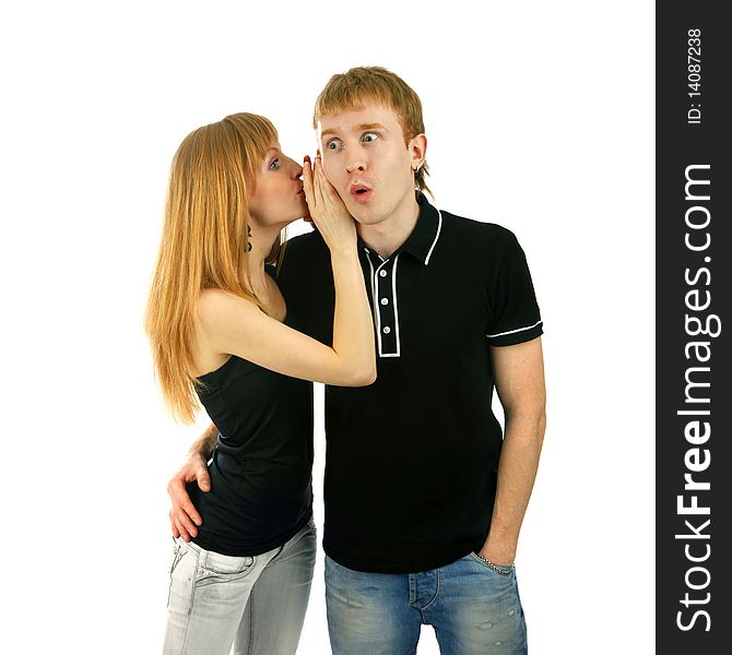 Beautiful woman whispering to a surprised man isolated background. Beautiful woman whispering to a surprised man isolated background