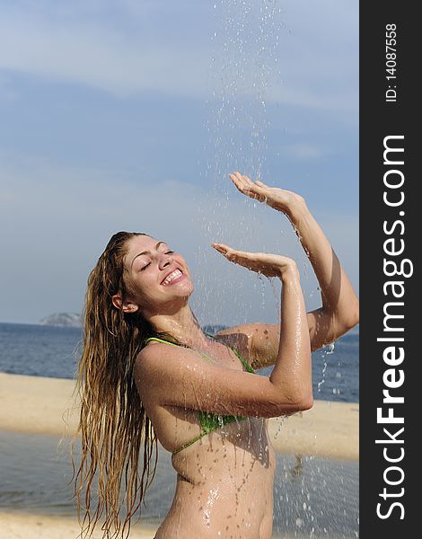 Summer vacation: woman taking a shower on the beach