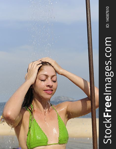 Summer vacation: woman taking a shower on the beach