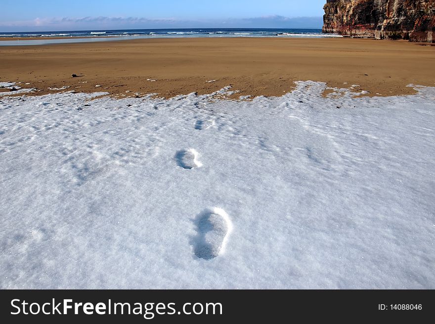 Footprints on an empty beach on a cold winters day