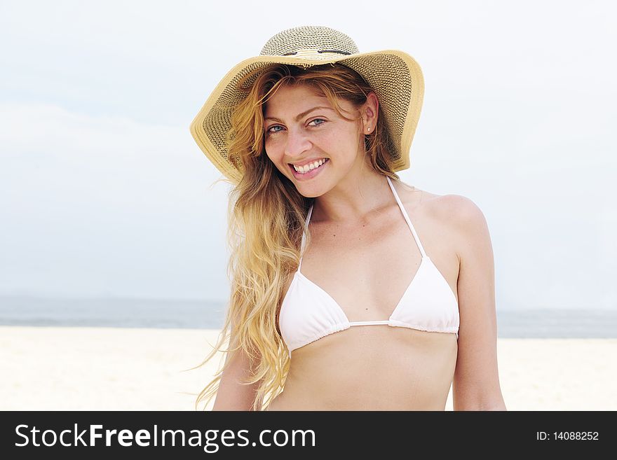 Beautiful woman on the beach with hat and copy space