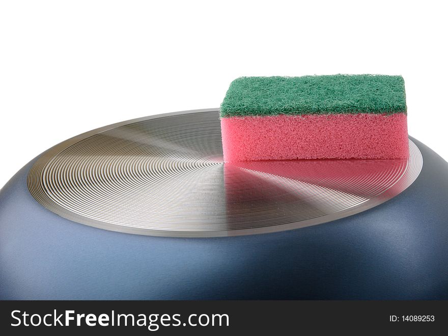 Sponge for ware lies on turned frying pan isolated in white