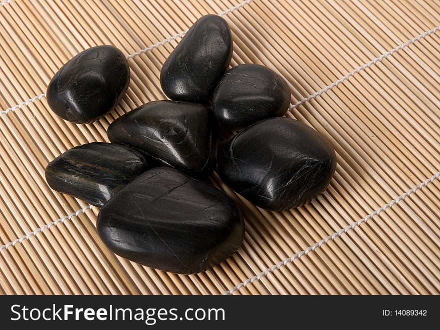 Some dark brilliant stones lie on mat