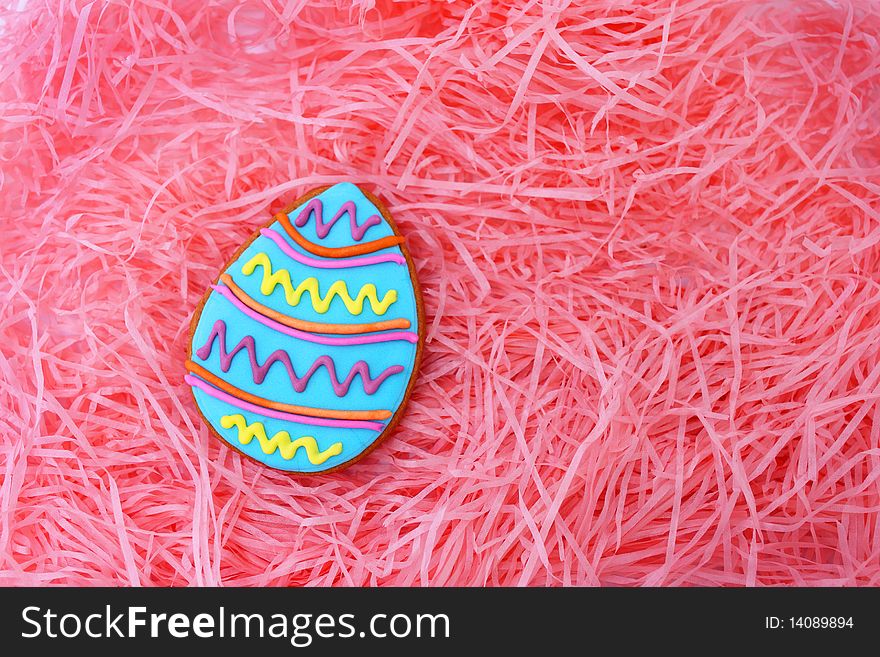 Close up of easter egg cookie on pink ribbons as background.