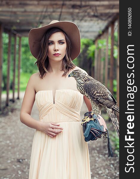 Sensual Woman Wearing Peach Color Dress And Brown Hat With Bird, Outdoor Fashion Portrait