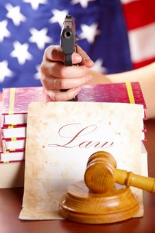 Hand With Gun And Judges Gavel Royalty Free Stock Image