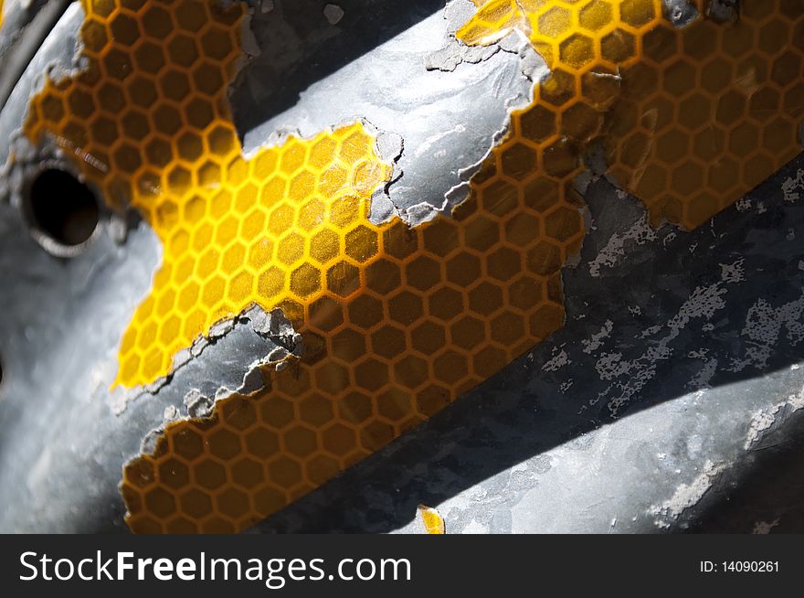 Yellow decayed reflector on a piece of metal.