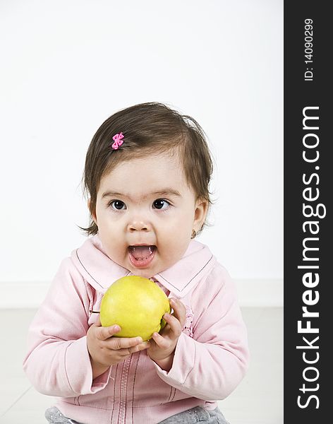 Cheerful baby ready to bite an apple