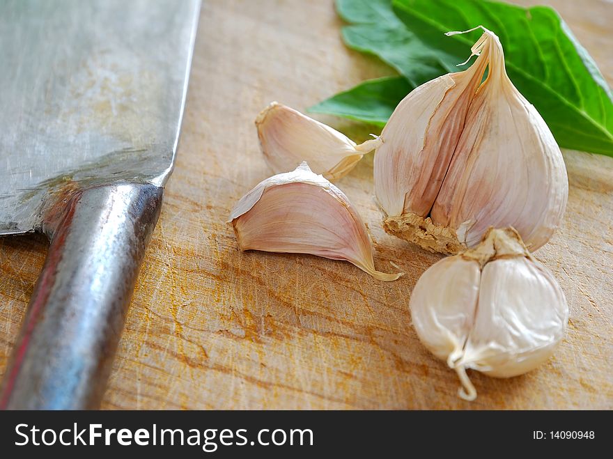 Fresh white garlic on chopping board with knife. Commonly used as seasoning and food ingredient in many Chinese cuisine. For food and beverage concepts. Fresh white garlic on chopping board with knife. Commonly used as seasoning and food ingredient in many Chinese cuisine. For food and beverage concepts.